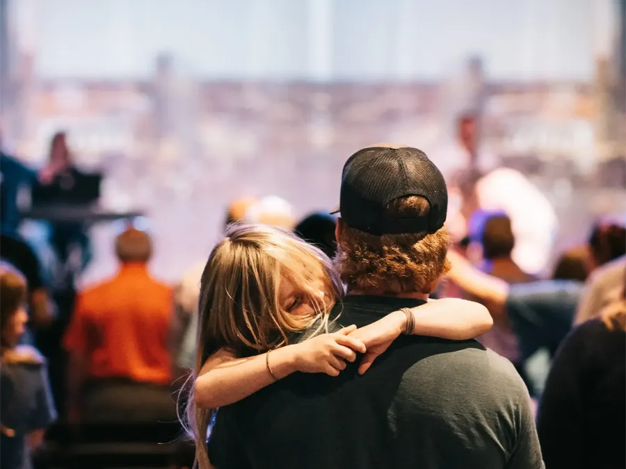 Father and daughter worshipping during Sunday service